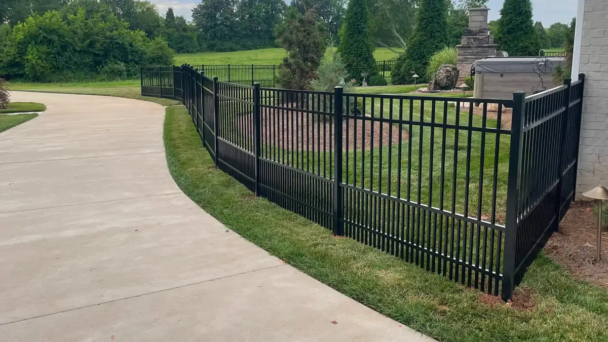 Black aluminum fence along a driveway