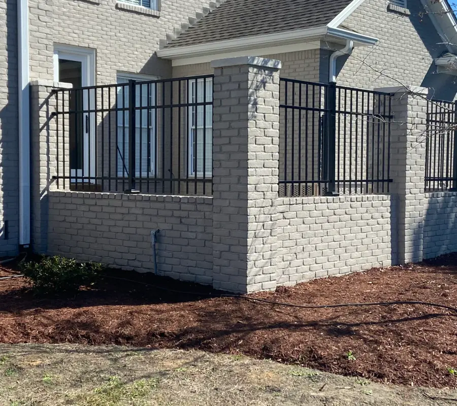 Ornamental iron fence between brick columns