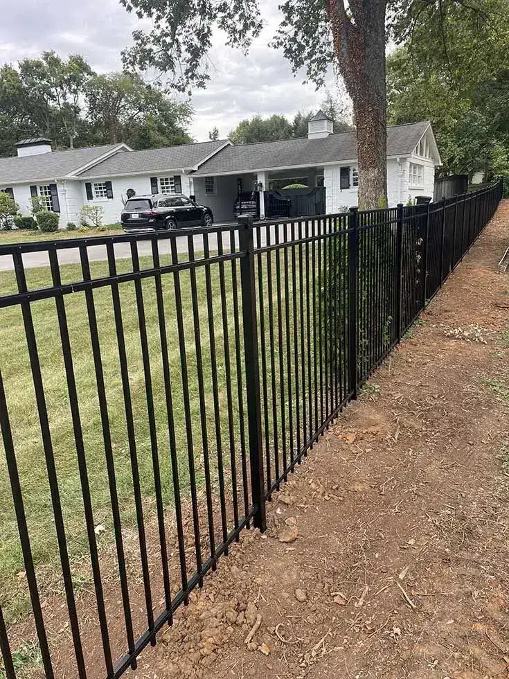 Black ornamental fence beside a home