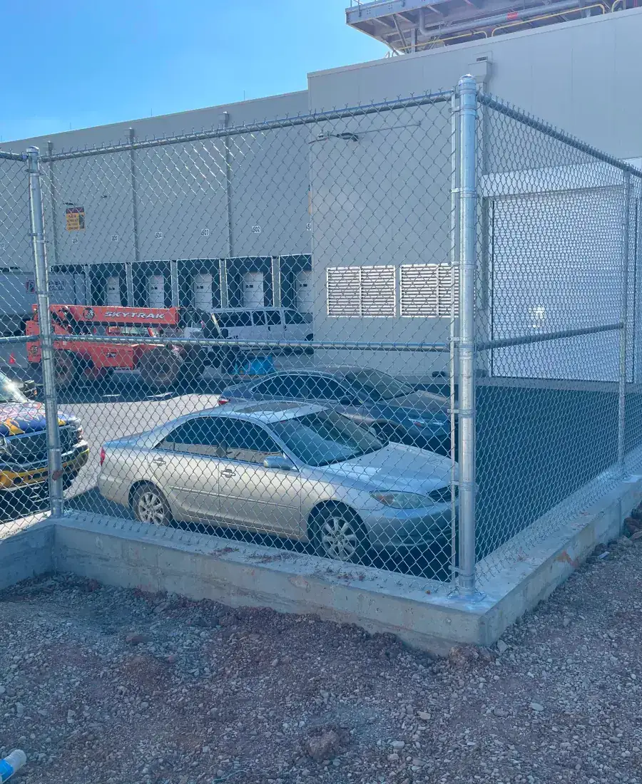 Chain link enclosure with barbed wire top