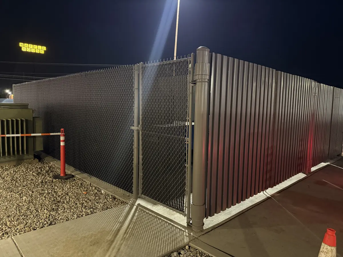 Steel panel and chain link screening enclosure at night