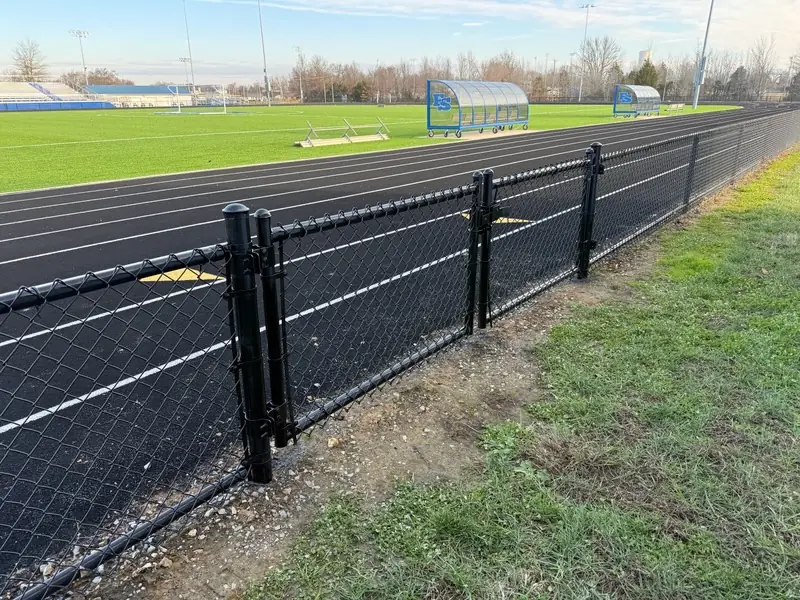 Black chain link fence along a running track