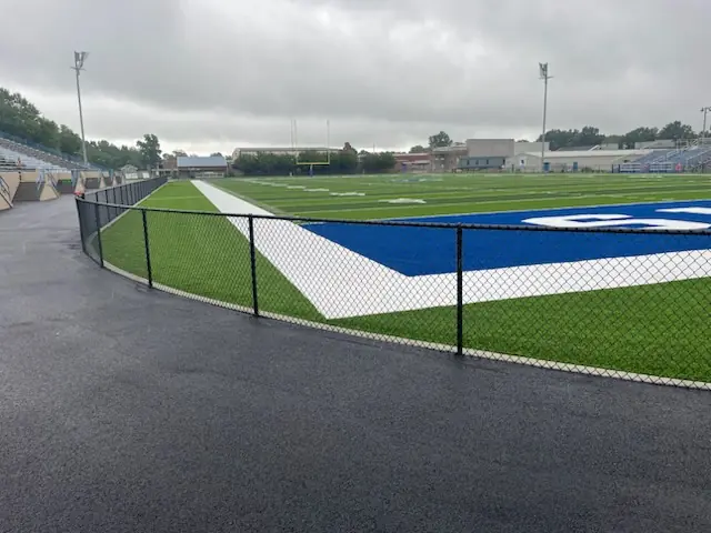 Black fence around a football field and track