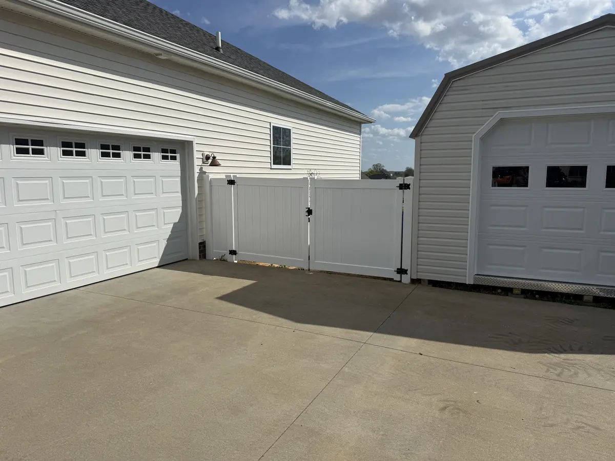 White vinyl gate beside a garage