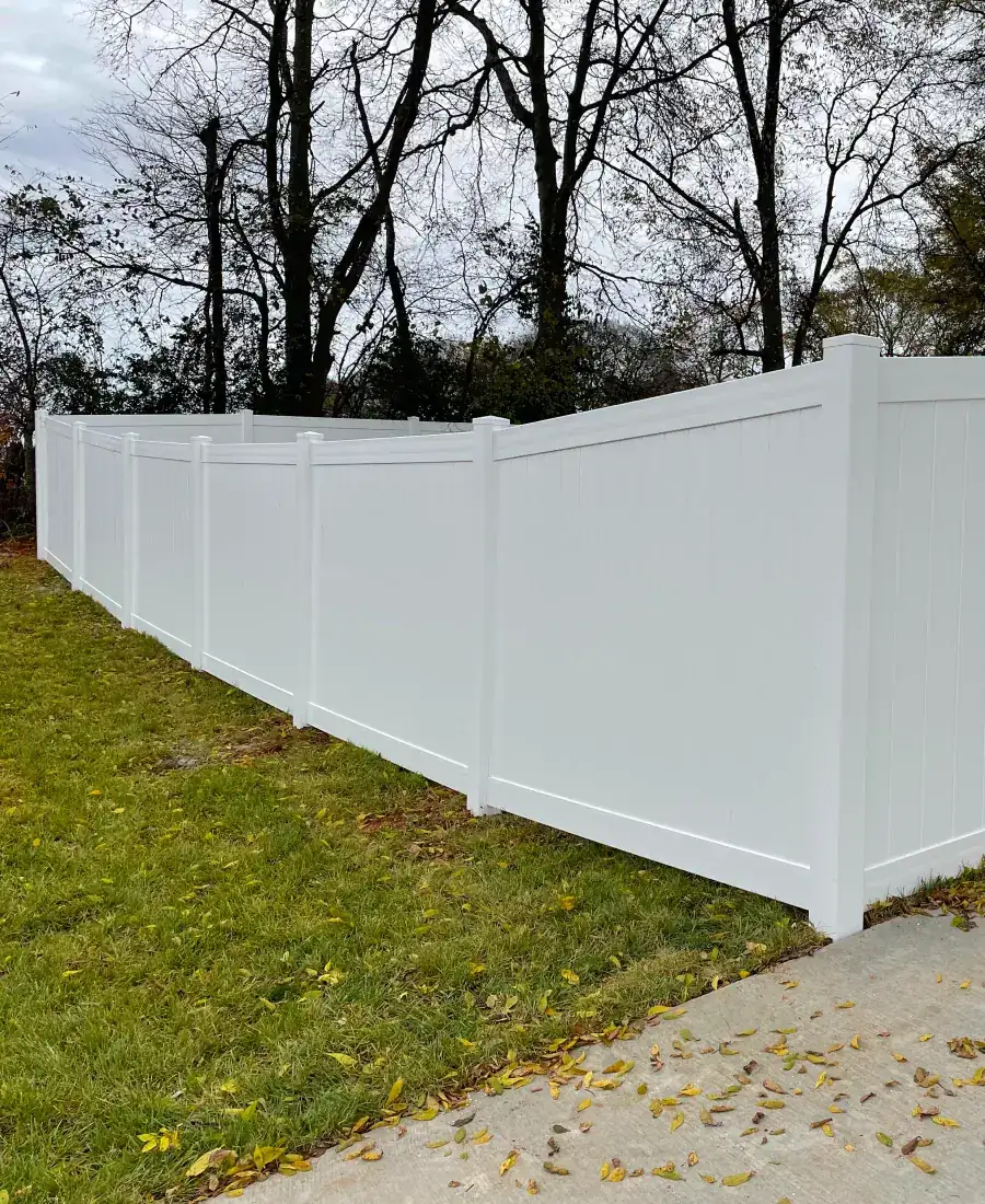 White vinyl privacy fence on a slope