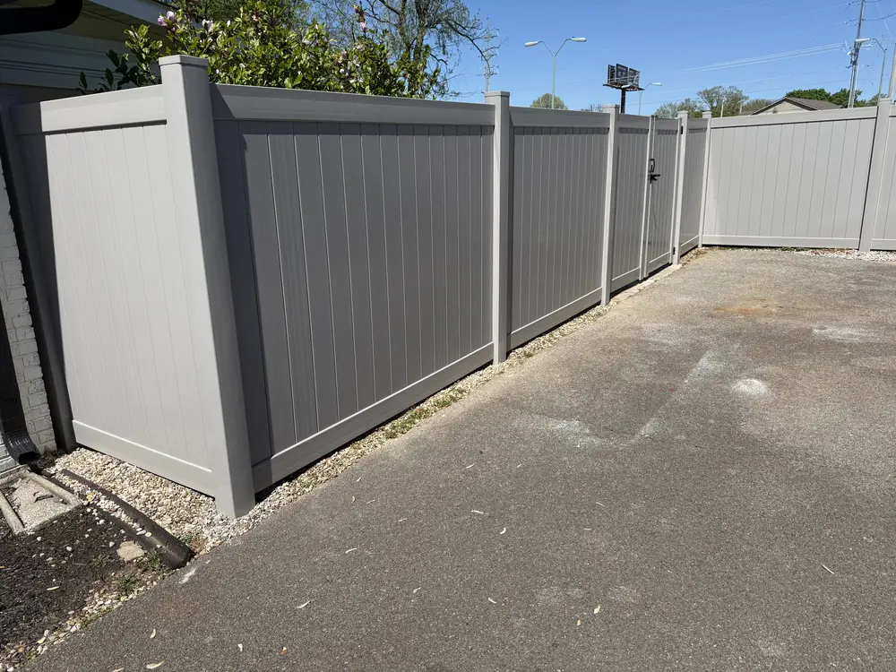 Gray vinyl privacy fence along a driveway